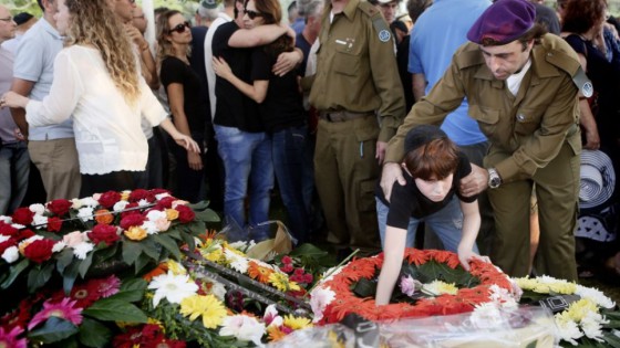 The son of IDF Major Amotz Greenberg (res.), 45, seen at the grave of his father during the funeral at the military cemetery in Hod HaSharon on Sunday, July 20, 2014. Greenberg was killed by Hamas terrorists who tunneled into Israel and opened fire on his army vehicle on July 19. (Photo credit: Miriam Alster/Flash90)