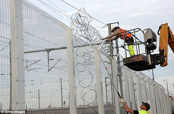2E1550FE00000578-0-Workers_reinforce_a_fence_with_razor_wire_to_protect_the_Eurotun-a-111_1446736637433