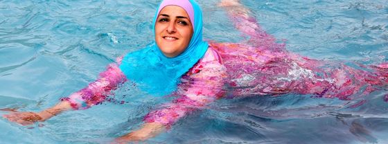Im Burkini kühlt sich die Berlinerin Abir am Montag (20.08.2012) in einem Freibad in Berlin. Nach dem bisher heissesten Wochenende des Jahres liegen die Temperaturen zum Wochenenfang immernoch über 30 Grad. Im Laufe der Woche sind Gewitter angekündigt un es soll kühler werden. Foto: Stephanie Pilick dpa/lbn