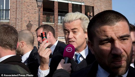 Firebrand Dutch lawmaker Geert Wilders talks to a TV reporters as he hands out 