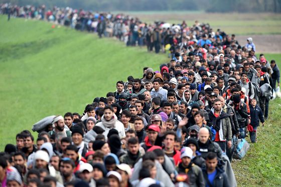 RIGONCE, SLOVENIA - OCTOBER 23: Migrants are escorted through fields by police as they are walked from the village of Rigonce to Brezice refugee camp on October 23, 2015 in Rigonce,, Slovenia. Thousands of migrants marched across the border between Croatia into Slovenia as authorities intensify their efforts to attempt to cope with Europe's largest migration of people since World War II. (Photo by Jeff J Mitchell/Getty Images)