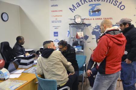Travel agent Muhiadin Hassan (L) helps a group of migrants to arrange for flights to Baghdad at his office in Helsinki, Finland, February 10, 2016. REUTERS/Tuomas Forsell