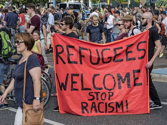 Germany-Headline-News-Now-Protesters-demonstrate-with-a-banner-saying-Refugees-welcome