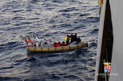 migranter-i-gummibåt-ved-italiensk-kystvaktskip